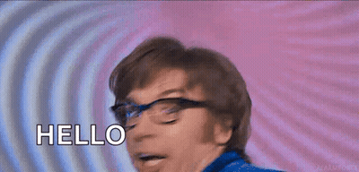 A Man Wearing Glasses Is Smiling And Saying Hello . GIF
