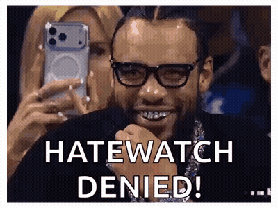 A Man Wearing Glasses Is Smiling While A Woman Takes A Picture Of Him With A Cell Phone . GIF