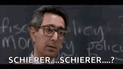 A Man Wearing Glasses Is Standing In Front Of A Blackboard With Chalk Writing On It . GIF