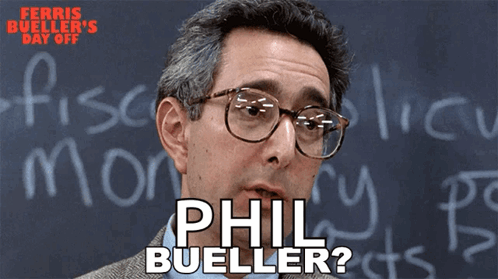 A Man Wearing Glasses Is Standing In Front Of A Blackboard With The Name Phil Bueller Written On It GIF