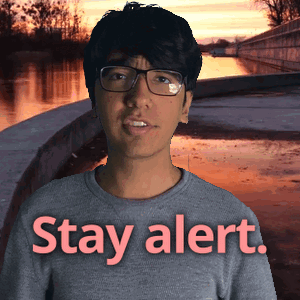 A Man Wearing Glasses Is Standing In Front Of A Sign That Says " Stay Alert " GIF