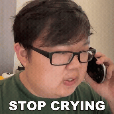 A Man Wearing Glasses Is Talking On A Cell Phone And Has The Words Stop Crying Written On His Face GIF
