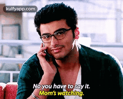 A Man Wearing Glasses Is Talking On A Cell Phone And Saying `` No You Have To Say It . Mom 'S Watching '' GIF