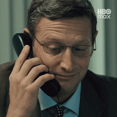 A Man Wearing Glasses Is Talking On A Telephone With Hbo Max Written On The Bottom GIF