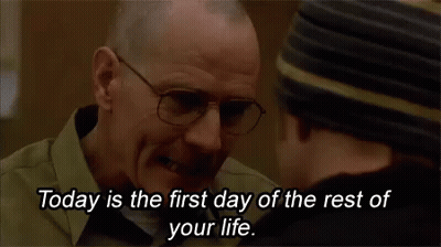 A Man Wearing Glasses Is Talking To Another Man In A Hat . GIF