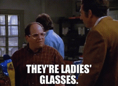 A Man Wearing Glasses Is Talking To Another Man In A Kitchen . GIF
