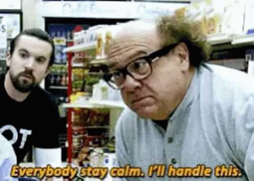 A Man Wearing Glasses Is Talking To Another Man In A Store While Another Man Watches . GIF