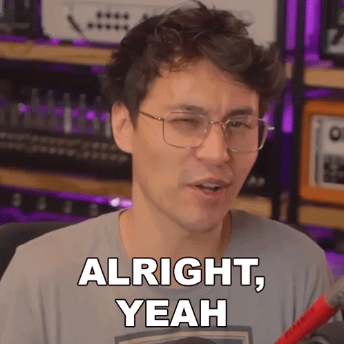 A Man Wearing Glasses Says " Alright Yeah " In Front Of A Microphone GIF
