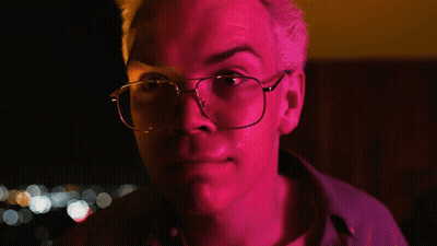 A Man Wearing Glasses Says Fair Enough In A Dark Room GIF