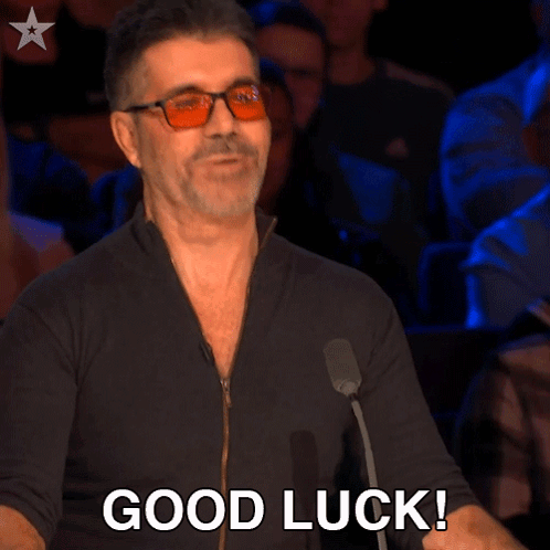 A Man Wearing Glasses Says " Good Luck " In Front Of A Crowd GIF