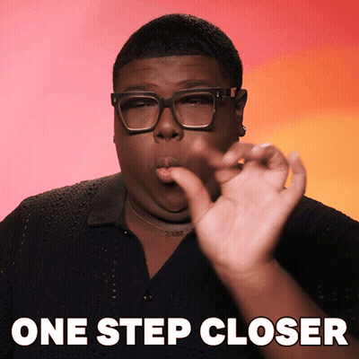A Man Wearing Glasses Says One Step Closer With His Hand GIF