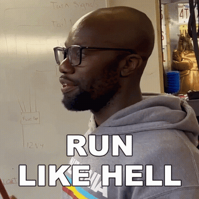 A Man Wearing Glasses Says Run Like Hell In Front Of A White Board GIF