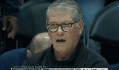 A Man Wearing Glasses Sits In The Stands Watching A Basketball Game GIF