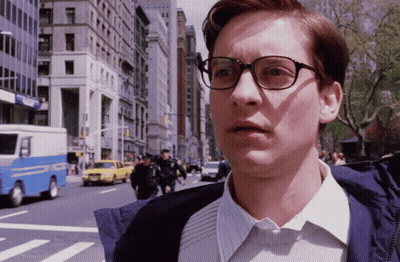 A Man Wearing Glasses Stands In Front Of A Blue And White Police Truck GIF