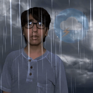 A Man Wearing Glasses Stands In Front Of A Cloud And Lightning Bolt GIF
