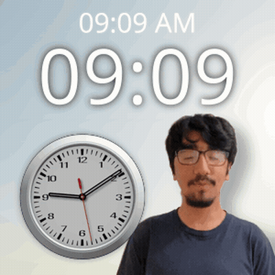 A Man Wearing Glasses Stands In Front Of A Wall Clock That Says 9:09 Am GIF