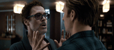 A Man Wearing Glasses Talks To Another Man In A Room GIF