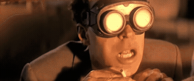 A Man Wearing Goggles Is Smoking A Cigarette And Making A Funny Face . GIF