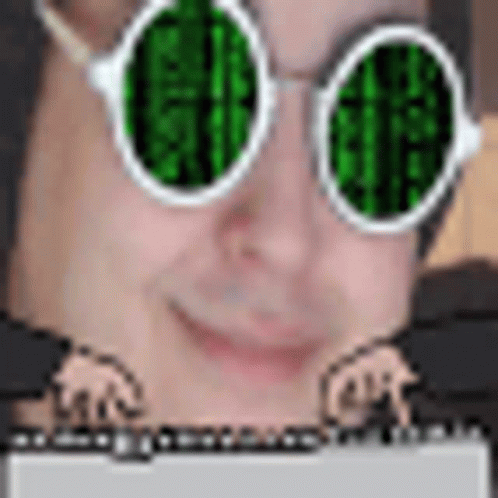 A Man Wearing Green Glasses Is Typing On A Laptop . GIF