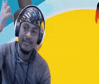 A Man Wearing Headphones And A Bandana On His Head Is Making A Peace Sign GIF