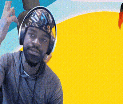 A Man Wearing Headphones And A Bandana With The Letter T On It Is Giving A Peace Sign GIF