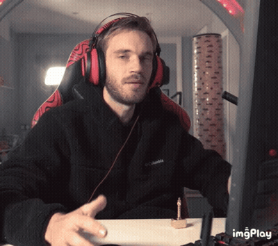 A Man Wearing Headphones And A Black Columbia Jacket Sitting At A Desk GIF