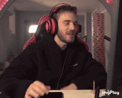 A Man Wearing Headphones And A Black Columbia Sweatshirt Is Sitting At A Desk GIF
