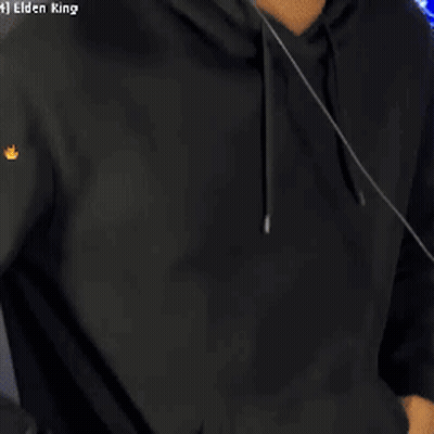 A Man Wearing Headphones And A Black Hoodie Is Standing In Front Of A Computer Screen . GIF