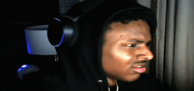 A Man Wearing Headphones And A Black Hoodie Looks To The Side GIF