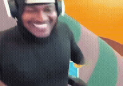 a man wearing headphones and a black shirt is smiling and looking at the camera .
