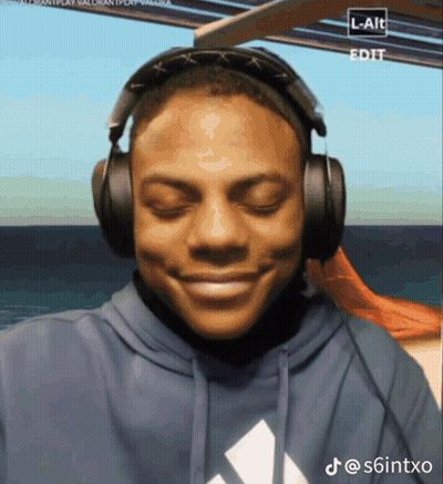 A Man Wearing Headphones And A Blue Adidas Sweatshirt Smiles GIF