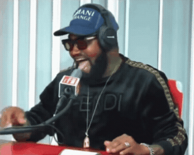 A Man Wearing Headphones And A Blue Hat That Says Mani Gang GIF