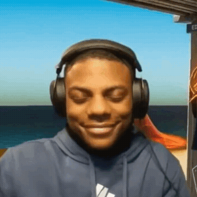 A Man Wearing Headphones And A Blue Hoodie Is Smiling GIF