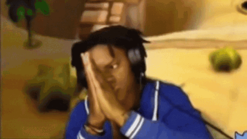 A Man Wearing Headphones And A Blue Jacket Is Praying In Front Of A Video Game . GIF