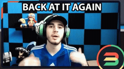 A Man Wearing Headphones And A Blue Shirt Is Giving A Thumbs Up In Front Of A Checkered Wall . GIF