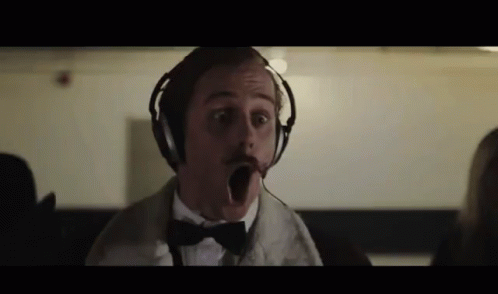 A Man Wearing Headphones And A Bow Tie Makes A Funny Face GIF