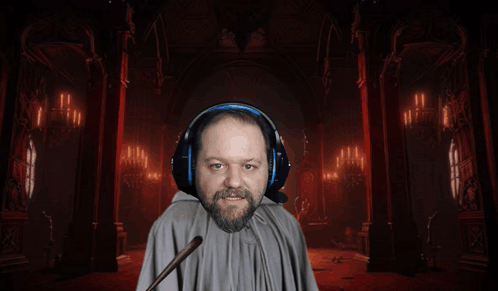 A Man Wearing Headphones And A Cape Holds A Green Wand GIF