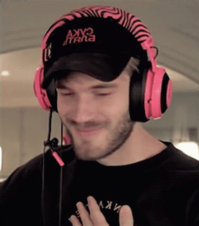 A Man Wearing Headphones And A Hat Is Making A Face . GIF