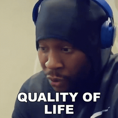 A Man Wearing Headphones And A Hat Is Making A Funny Face And Saying Quality Of Life . GIF