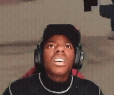 A Man Wearing Headphones And A Hat Is Making A Surprised Face . GIF