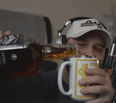 A Man Wearing Headphones And A Hat Is Pouring A Drink Into A Mug That Has The Letter A On It GIF