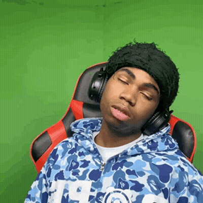 A Man Wearing Headphones And A Hat Is Sitting In A Chair . GIF