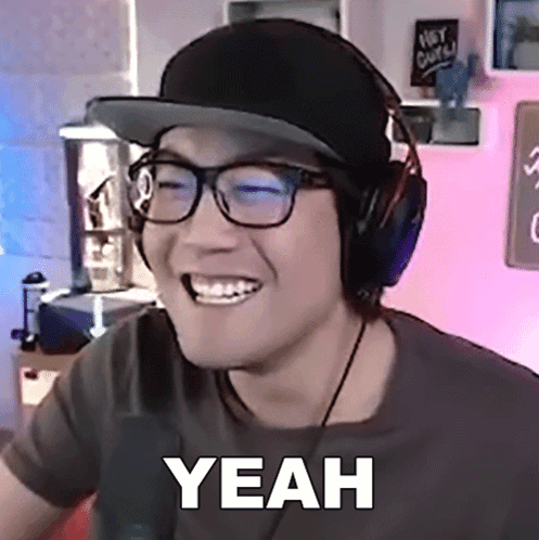 A Man Wearing Headphones And A Hat Is Smiling And Says Yeah GIF