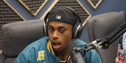 A Man Wearing Headphones And A Hat With The Letter N On It GIF