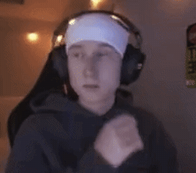 A Man Wearing Headphones And A Headband Is Sitting In Front Of A Computer . GIF