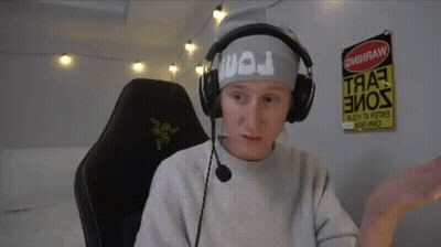 A Man Wearing Headphones And A Headband With The Letter J On It Sits In A Chair GIF
