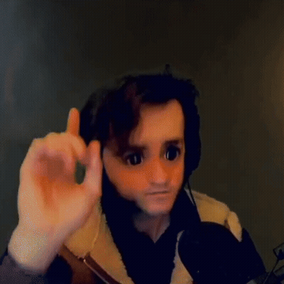 A Man Wearing Headphones And A Mask Is Giving A Thumbs Up Sign While Sitting In Front Of A Microphone . GIF