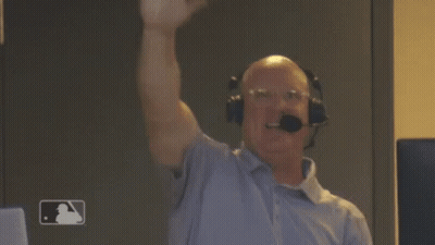 A Man Wearing Headphones And A Microphone Holds His Fist In The Air . GIF