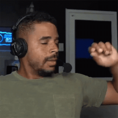 A Man Wearing Headphones And A Microphone Is Dancing In Front Of A Computer Screen . GIF