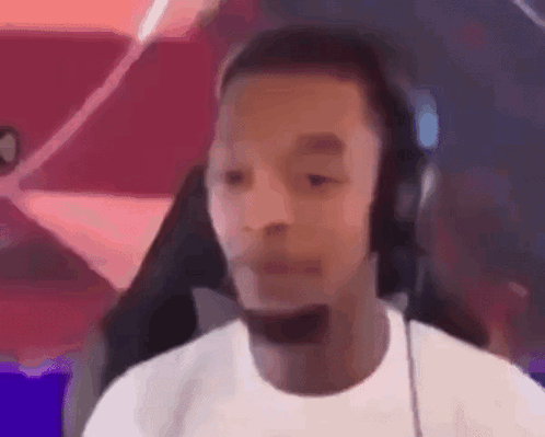 A Man Wearing Headphones And A Microphone Is Making A Funny Face . GIF